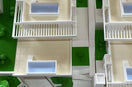 Multi-colour 3D printed architectural model with white buildings, green landscaping and blue pools — Eolas Prints