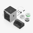 Black and gray cube-shaped 3D printer with accessories and filament spools.