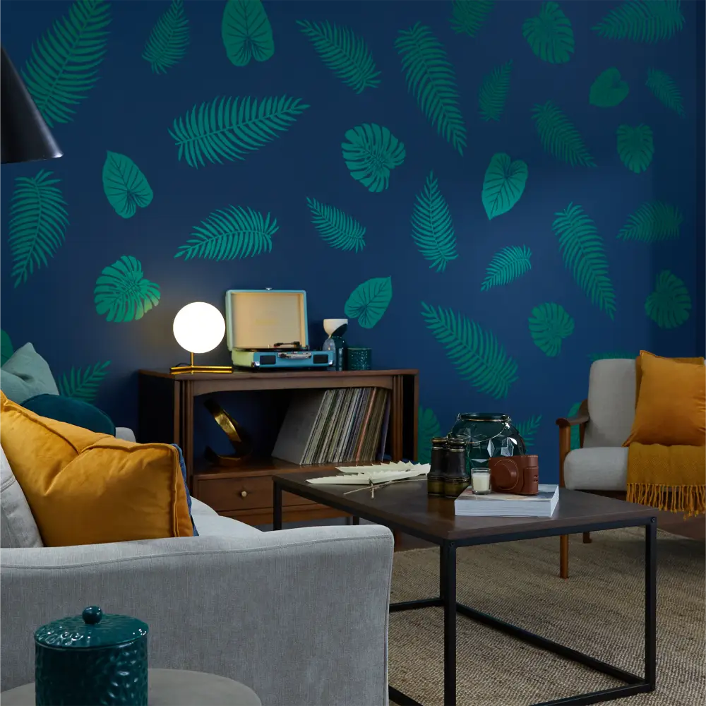 Tropical palm and monstera leaf pattern wallpaper in teal on a navy background.