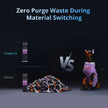 A doberman pinscher in a purple and orange outfit stands upright beside the flashforge creator 5 with independent toolheads