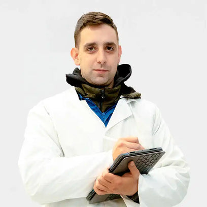 A person wearing a white lab coat and holding a tablet device.