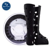 Black medical boot or orthopedic brace next to a spool of 3D printer filament.