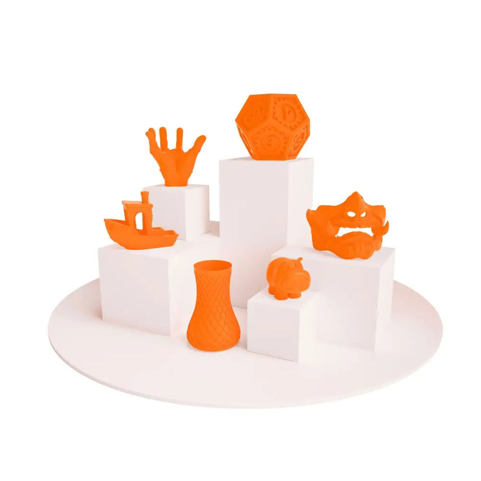 Display of vibrant orange 3D printed objects using PLA Neon Filament for creative projects