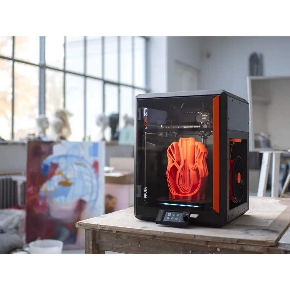 Black and orange 3D printer with transparent enclosure.