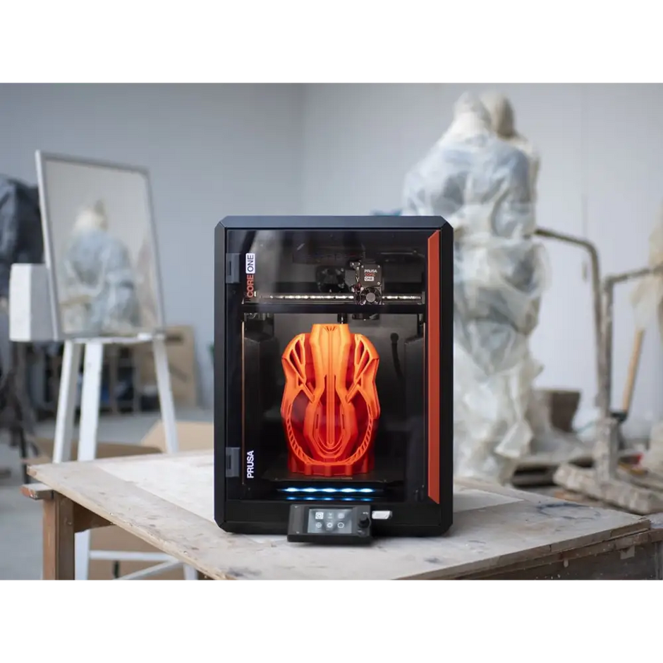 Black and orange 3D printer with transparent enclosure.