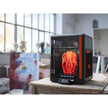Black and orange 3D printer with transparent enclosure.