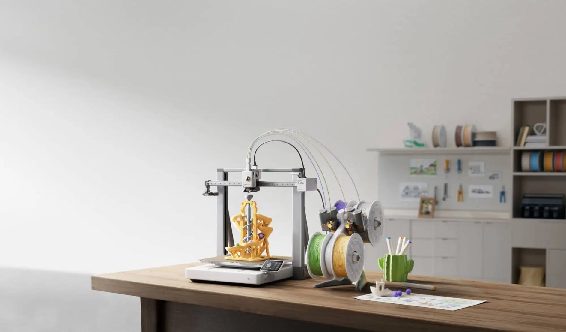 Silver and black desktop 3d printer with multiple filament spools nearby